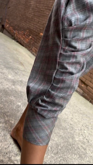 A person wearing a pair of pants with a plaid pattern.