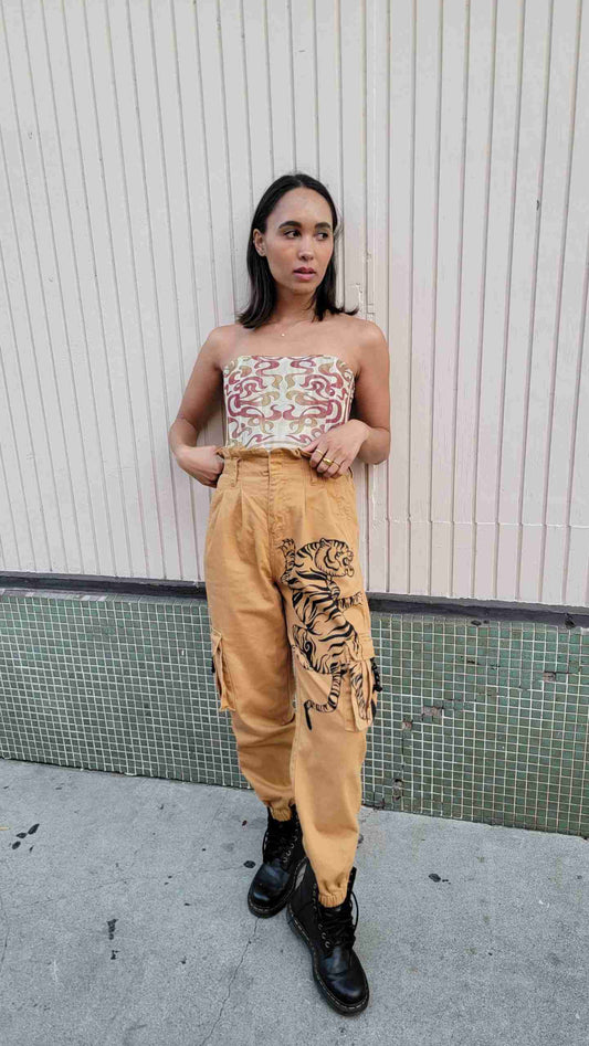 a woman leaning against a wall with her hands on her hips.