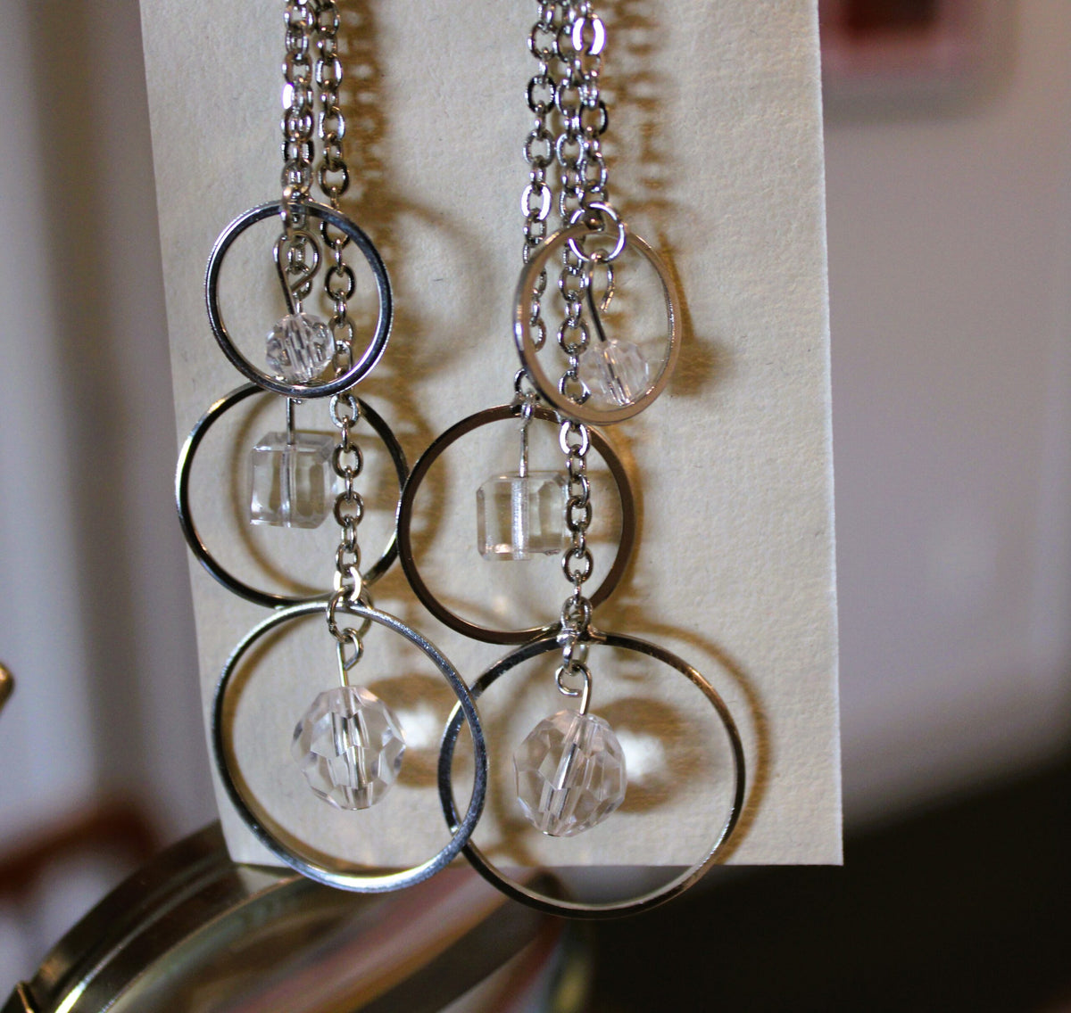 A pair of earrings hanging from a piece of paper.