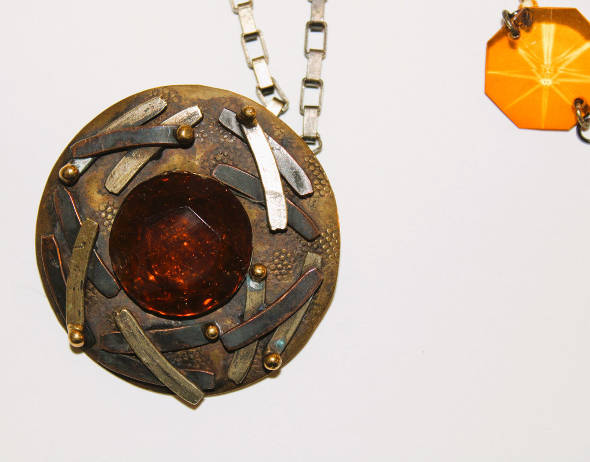 A necklace with a pendant and a pendant on a chain.
