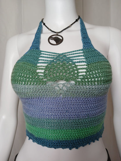 A purple and green crocheted top on a mannequin.