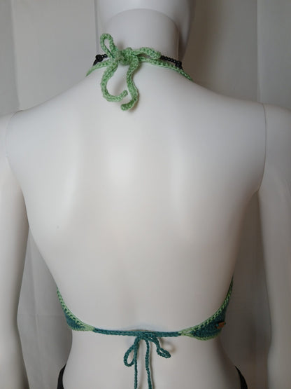 The back of a mannequin wearing a green halter.