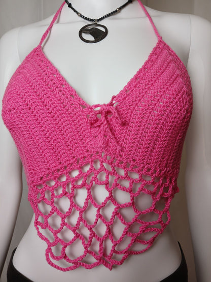 A pink crocheted cropped halter top on a mannequin.