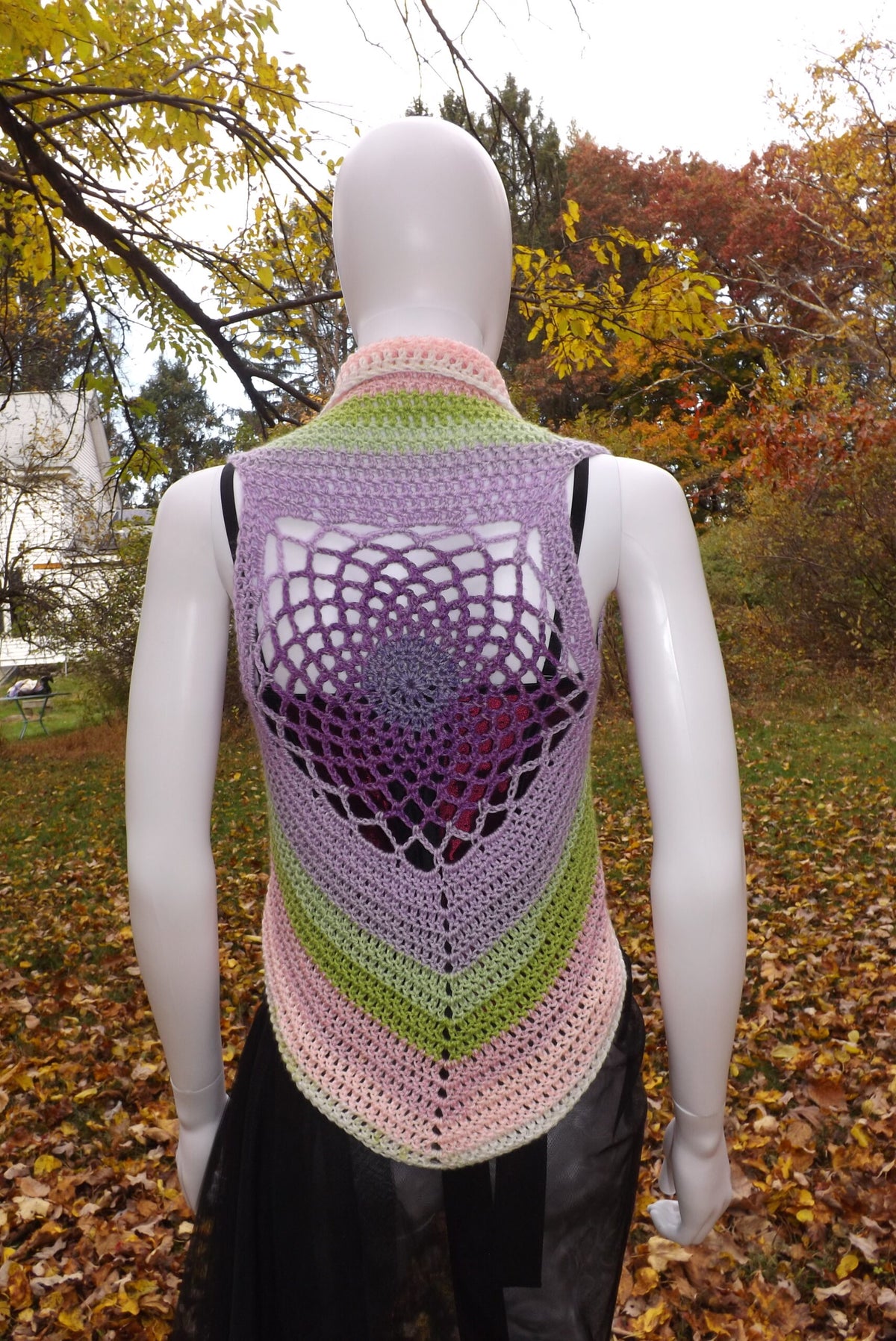 A crochet crop top vest with web motif in pastel shades.