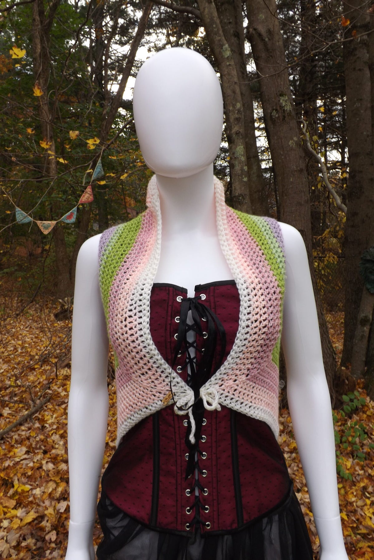 A crochet crop top with front tie in pink, green and white.