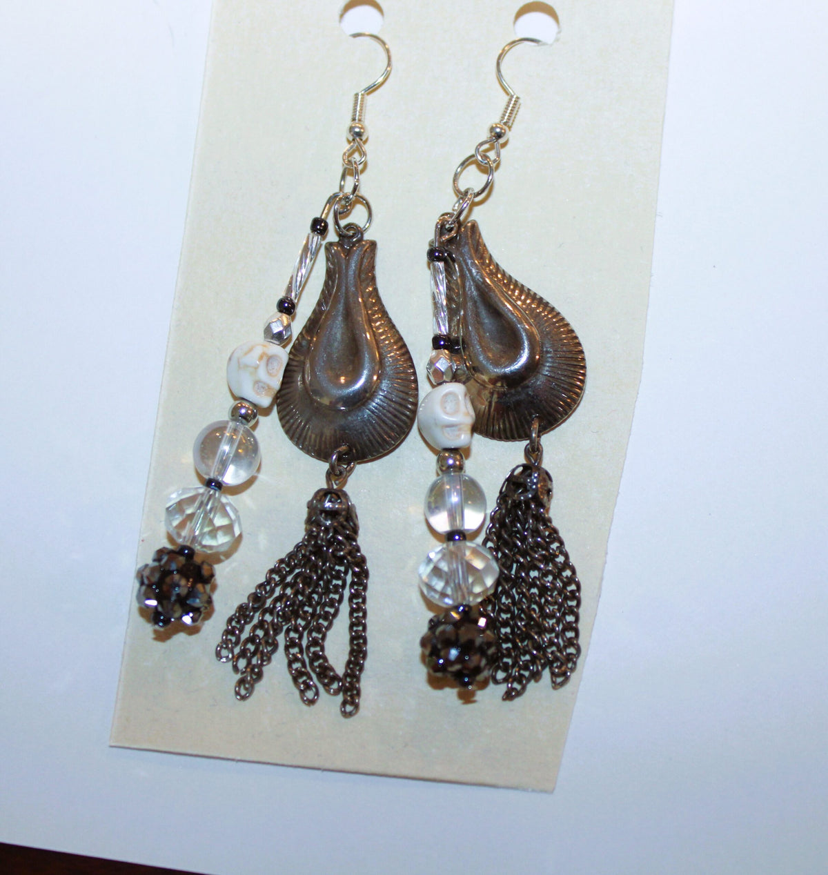A pair of earrings with tassels hanging from them.