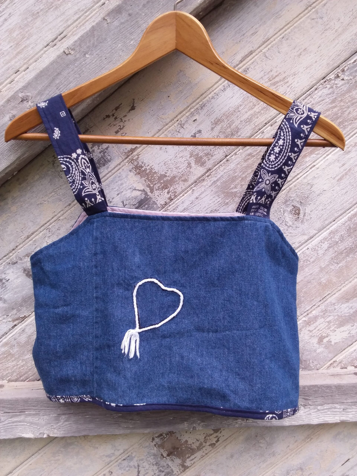 An upcycled blue denim crop top with bandana fabric straps and a heart on it.