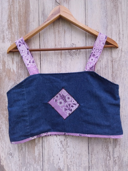 An upcycled denim and purple bandana fabric crop top on a wooden hanger