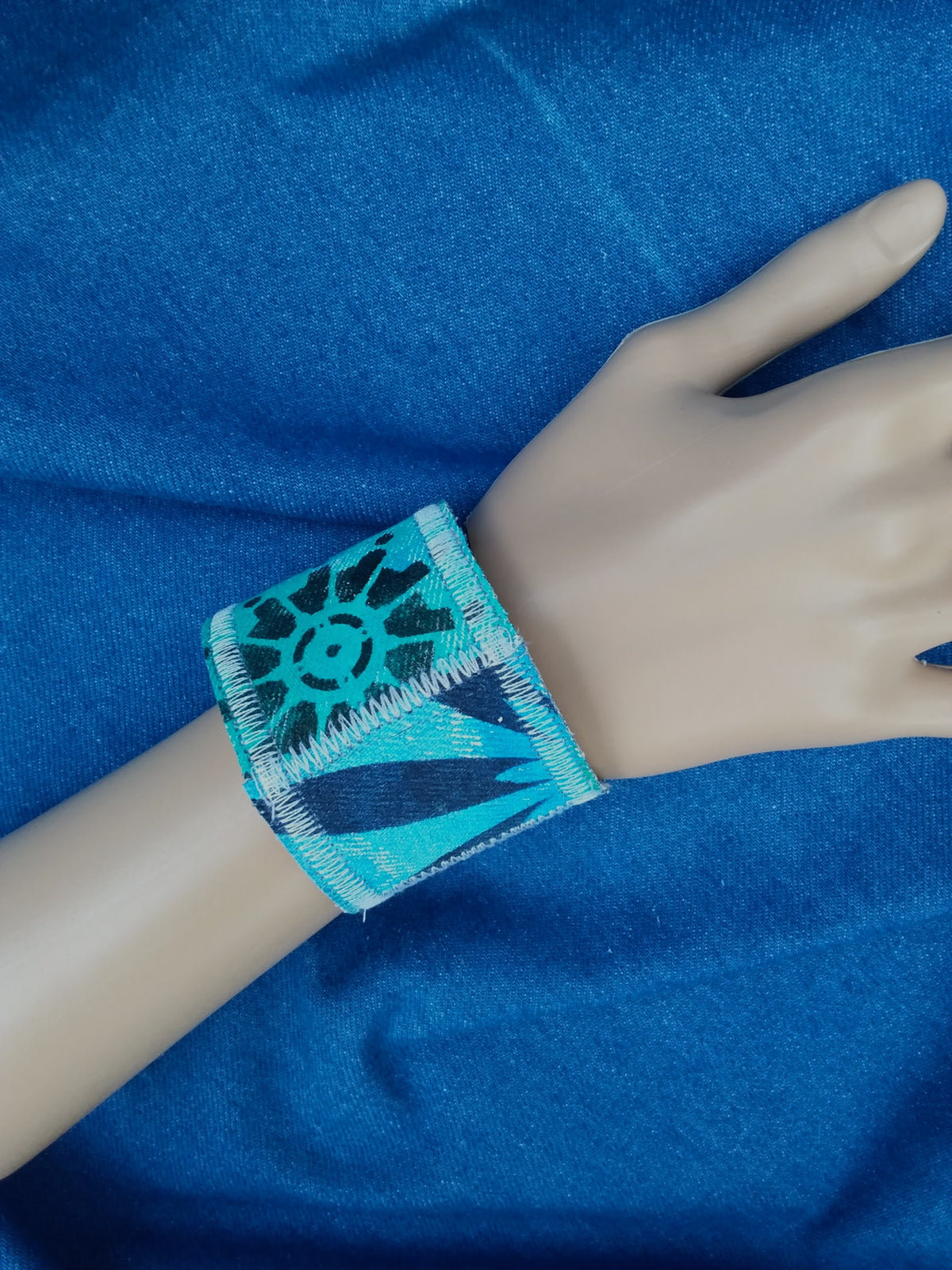 A hand painted, recycled denim cuff bracelet.