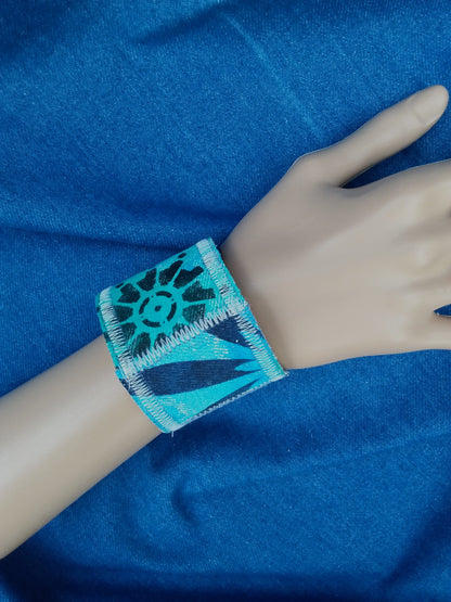 A hand painted, recycled denim cuff bracelet.