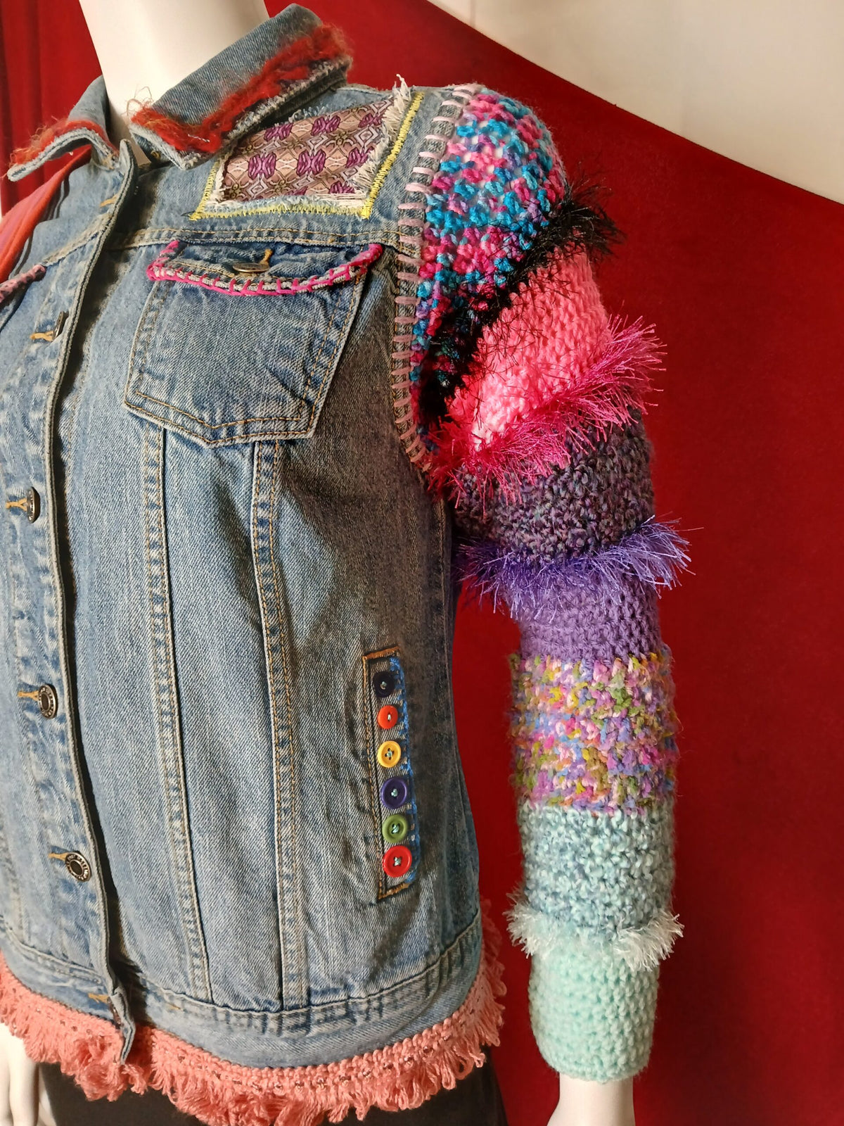 A colorful crochet and denim jacket with applique patches and embroidery