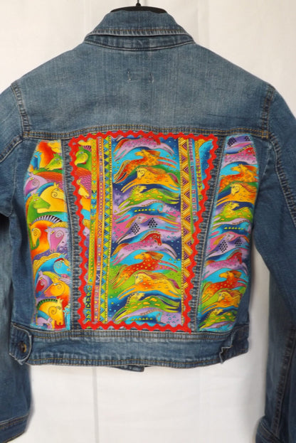 An upcycled denim jacket with vibrantly colored horse fabric and red rick rack trim.