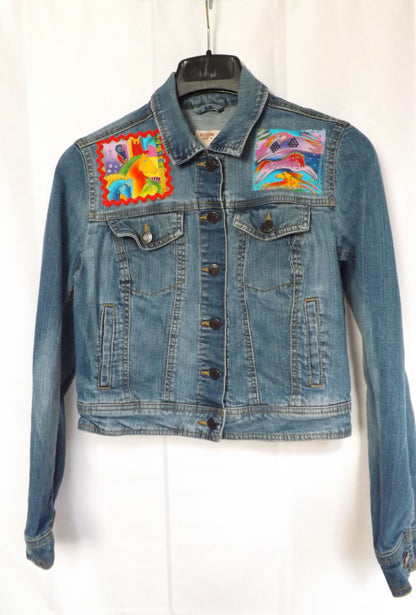 Vibrant horse fabric by Laurel Burch adorns a upcycled denim jacket