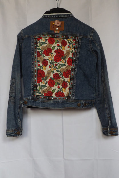 Red roses fabric and floral trim decorate a denim jeans jacket