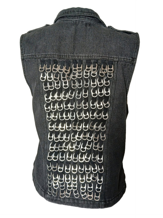 A denim vest adorned with numerous silver-colored pull tabs creating a pattern on the back.