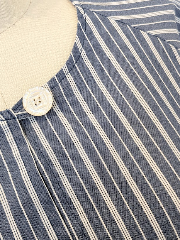 A close up of a blue and white striped shirt on a mannequin.