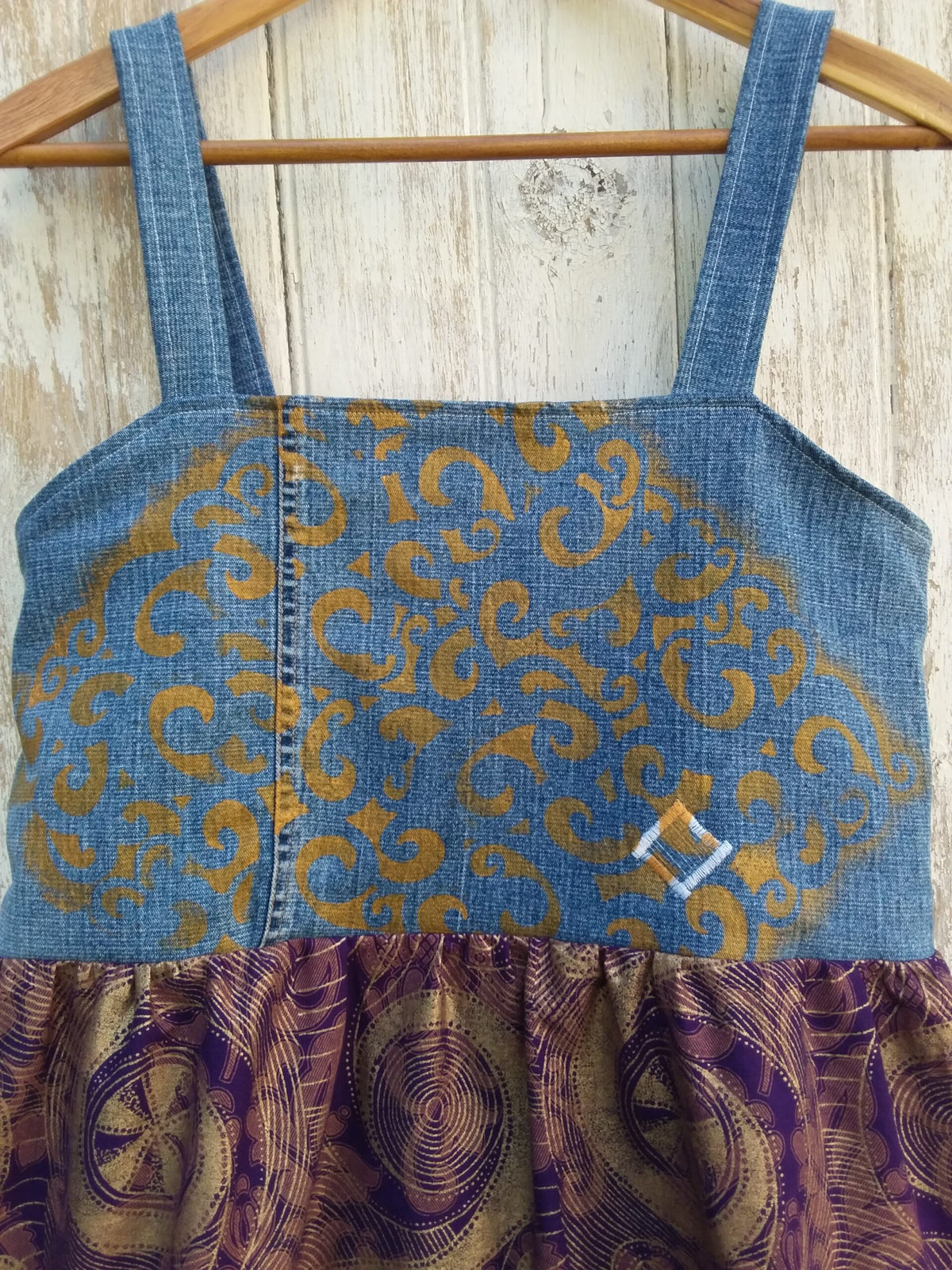 a denim dress with a gold and purple pattern.