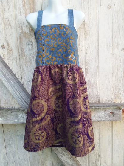 A mannequin with a hand painted, upcycled denim dress on it.