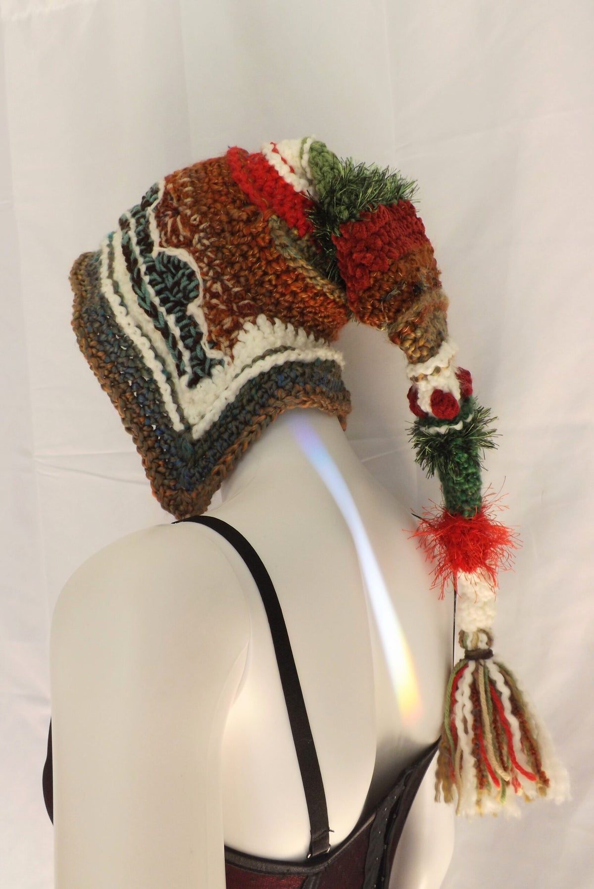 A mannequin wearing a knitted hat with a tassel.