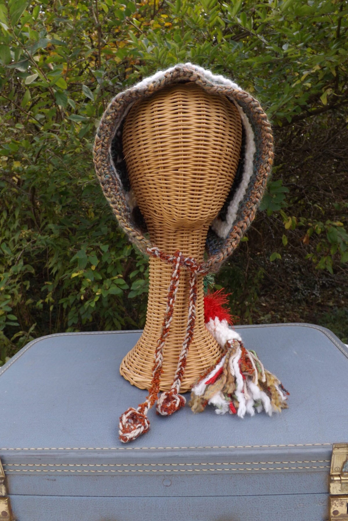 A crochet hat on top of a suitcase.