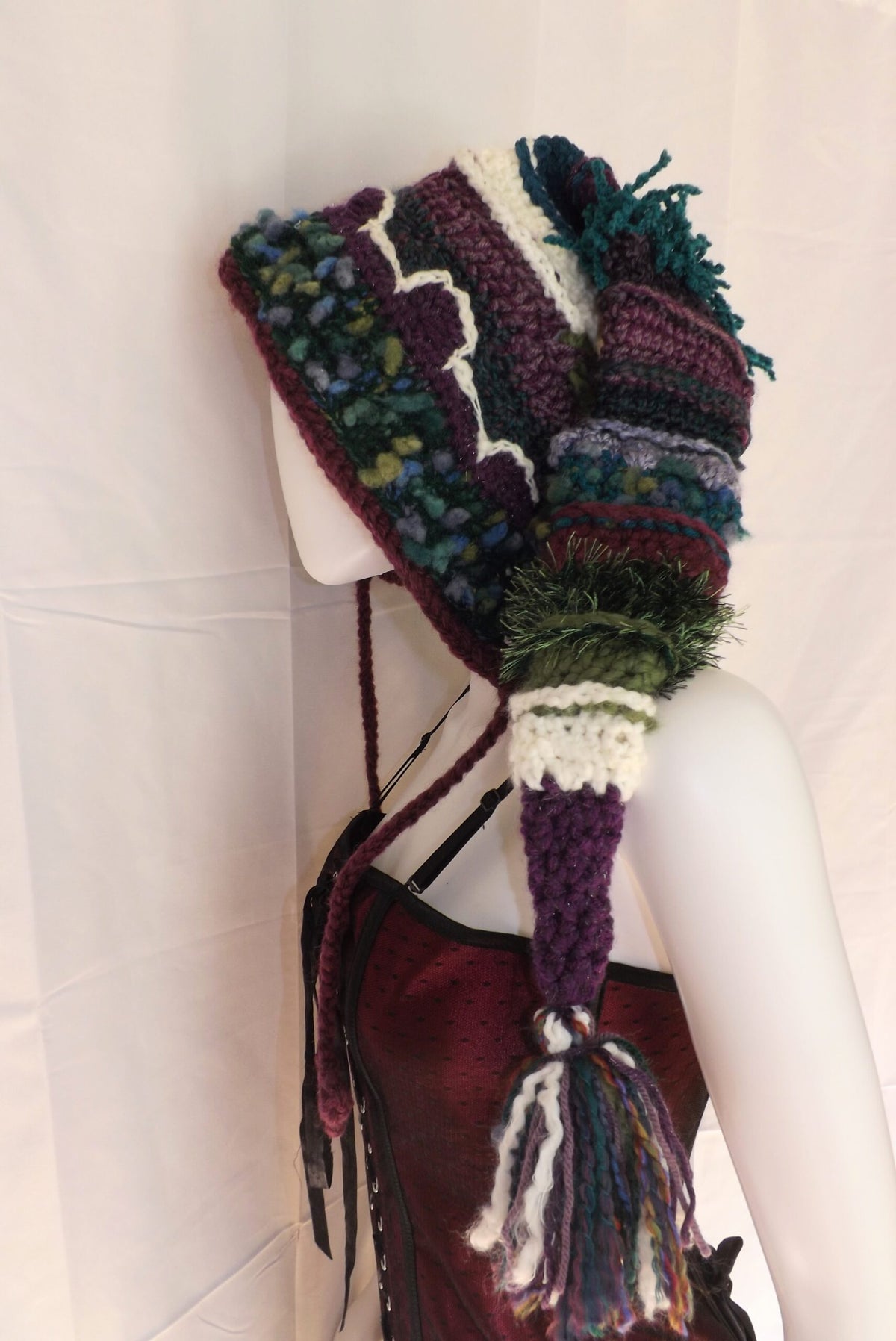 A mannequin wearing a knitted hat with a tassel.