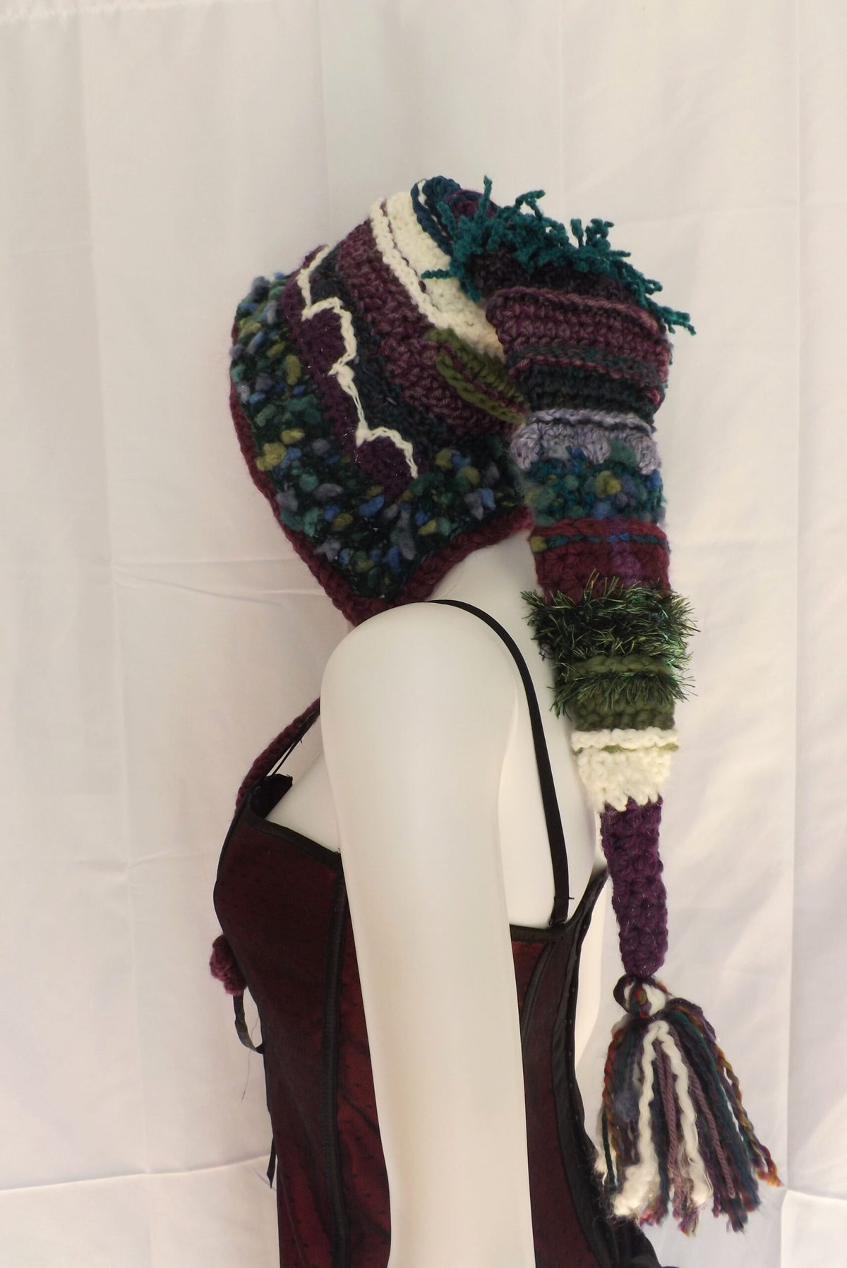 A mannequin wearing a knitted hat and scarf.