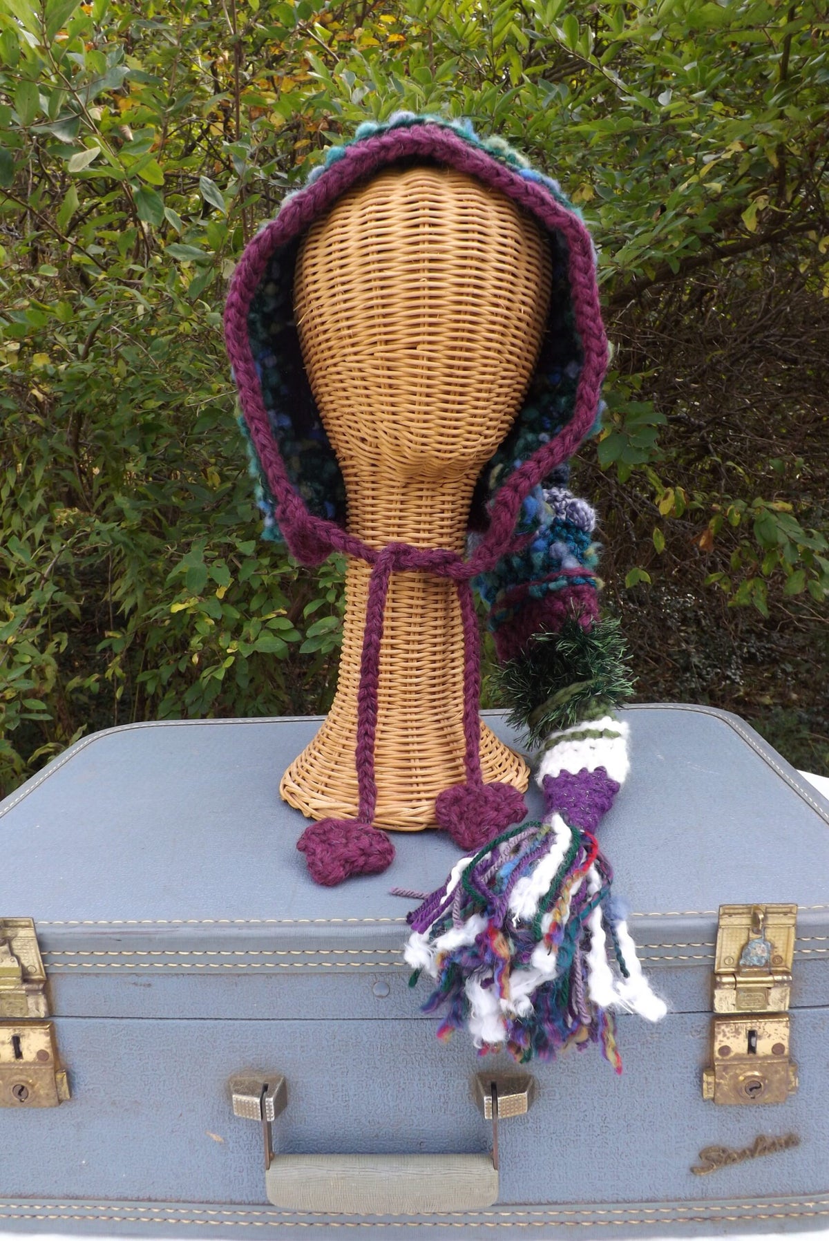 A crocheted hat on top of a suitcase.
