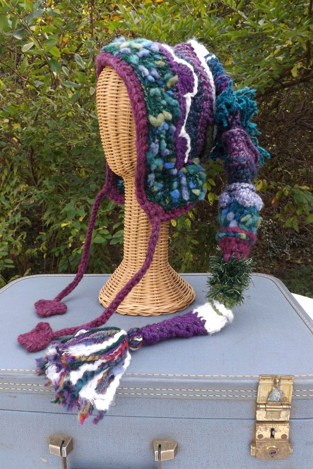 A crocheted hat on top of a suitcase.