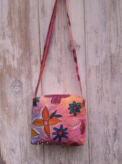Brightly colored hand painted flowers adorn a hand dyed handbag in pink, orange, blue and yellow