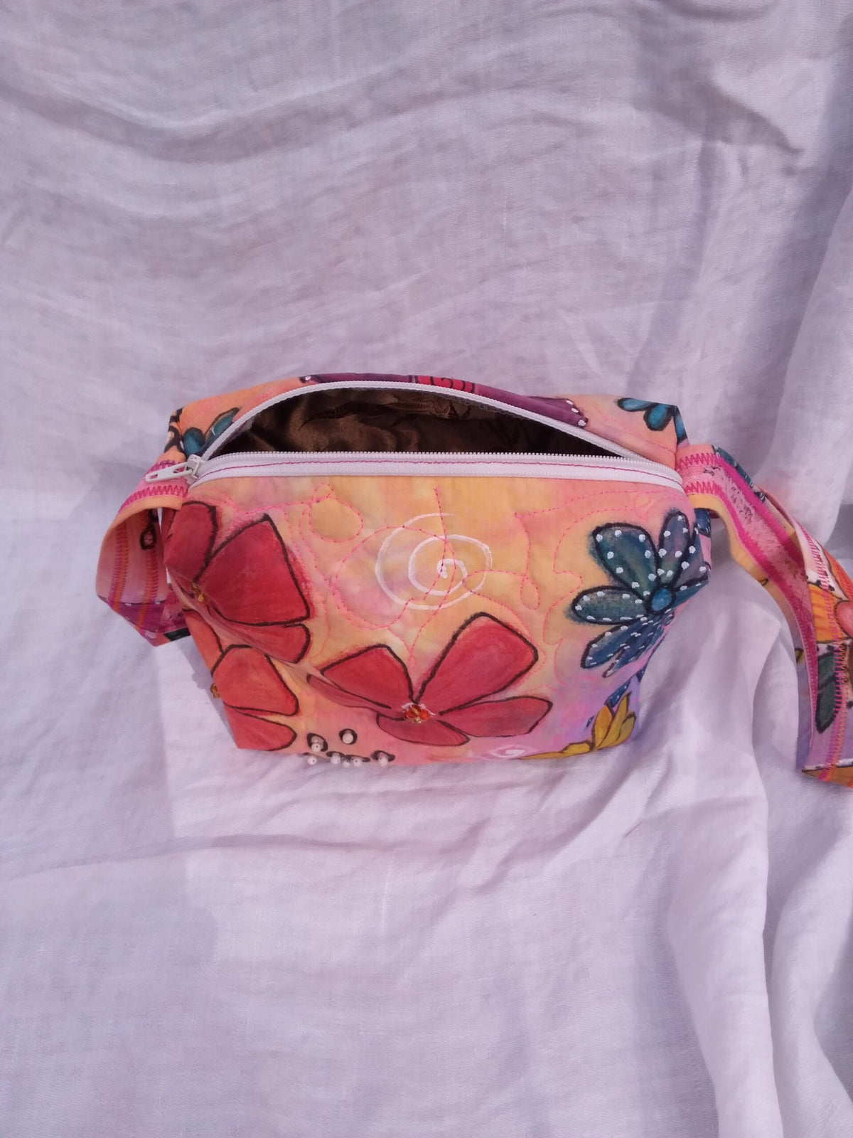 A hand dyed and painted purse with bold flowers, beads and quilting.
