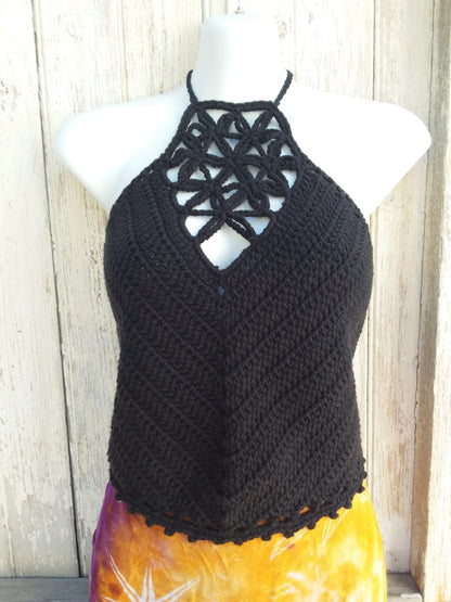 A black crochet halter top with picot edging paired with a bright orange skirt