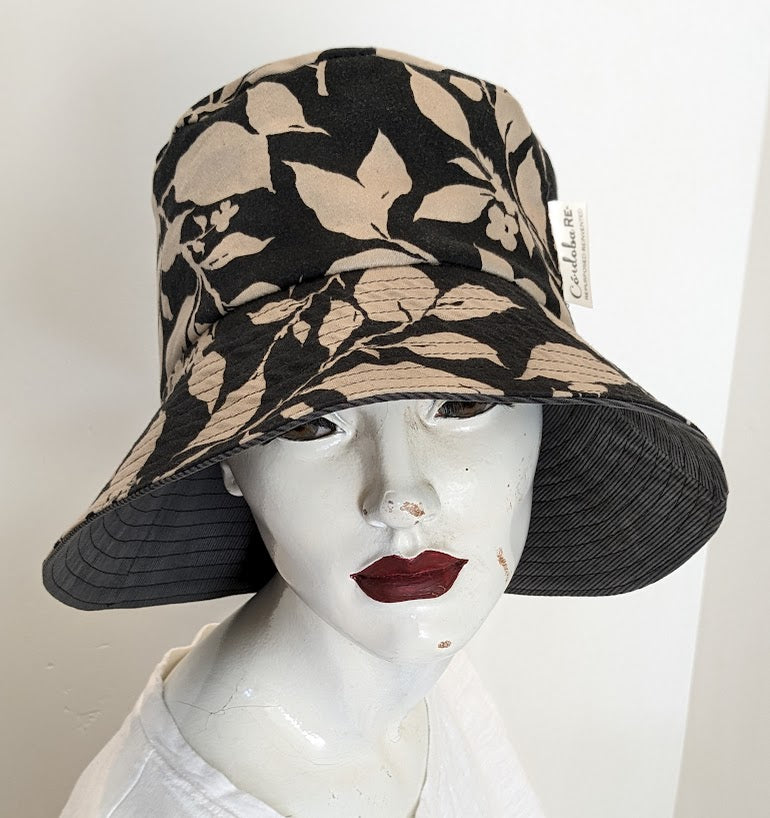 A mannequin wearing a black and beige hat.