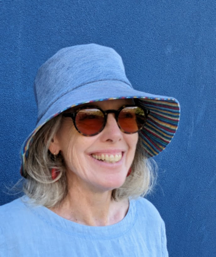 A woman wearing sunglasses and a blue hat.