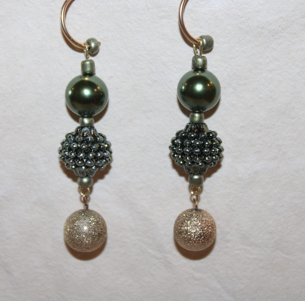 A pair of earrings with beads in the shape of little balls.