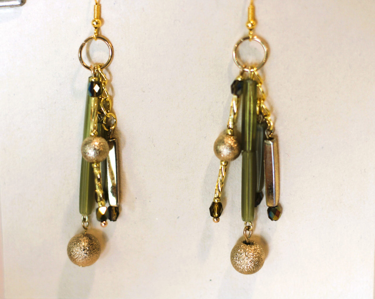 A pair of earrings with gold and green beads.