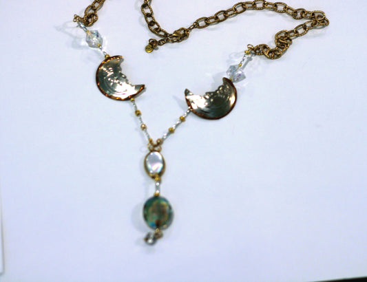 A necklace with a glass pendant and a gold chain.