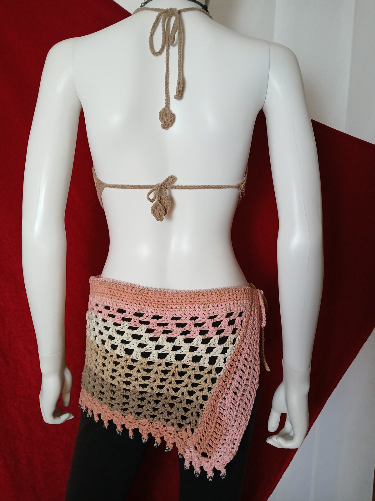 Mannequin displaying a handmade crochet halter top and matching skirt.