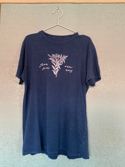 A blue t - shirt hanging on a hanger.