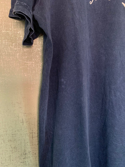 A blue t - shirt hanging on a wall.