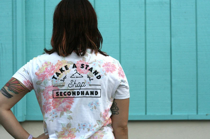A woman wearing a tie dye t - shirt with tattoos.