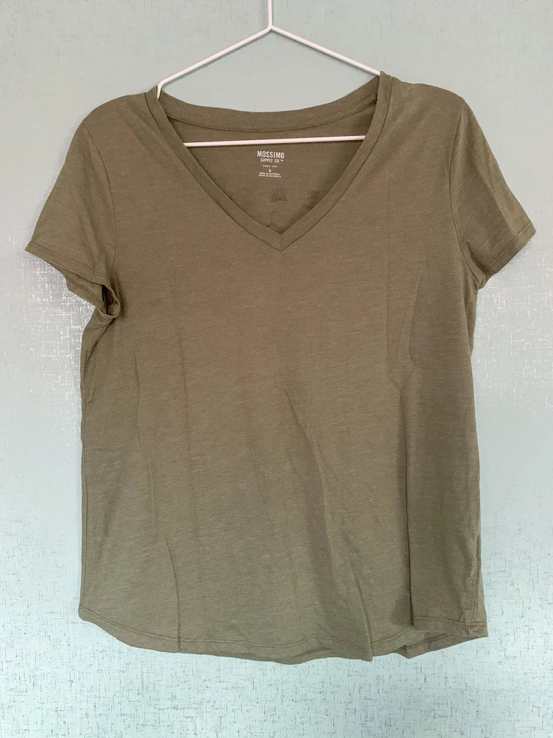 A green v - neck t - shirt hanging on a hanger.