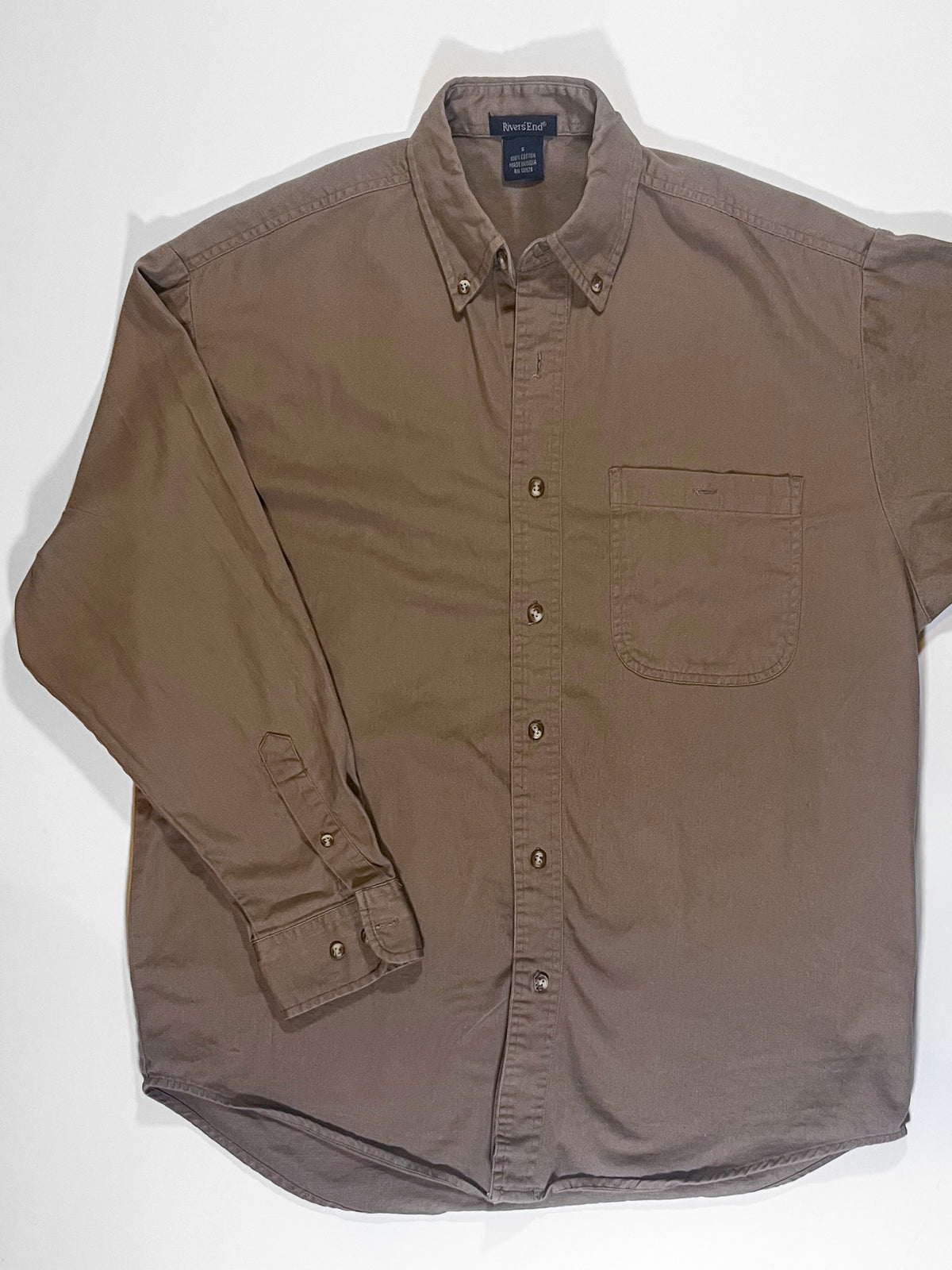 A Wide-Eyes Button-Down Shirt is laying on a white surface.