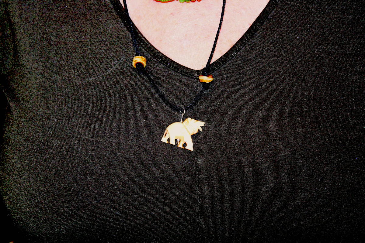 A woman wearing a necklace with a bear on it.