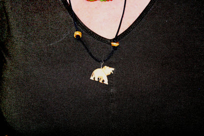 A woman wearing a necklace with a bear on it.