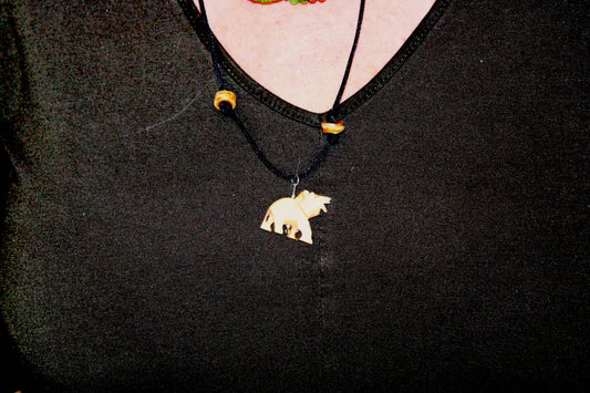 A woman wearing a necklace with a bear on it.