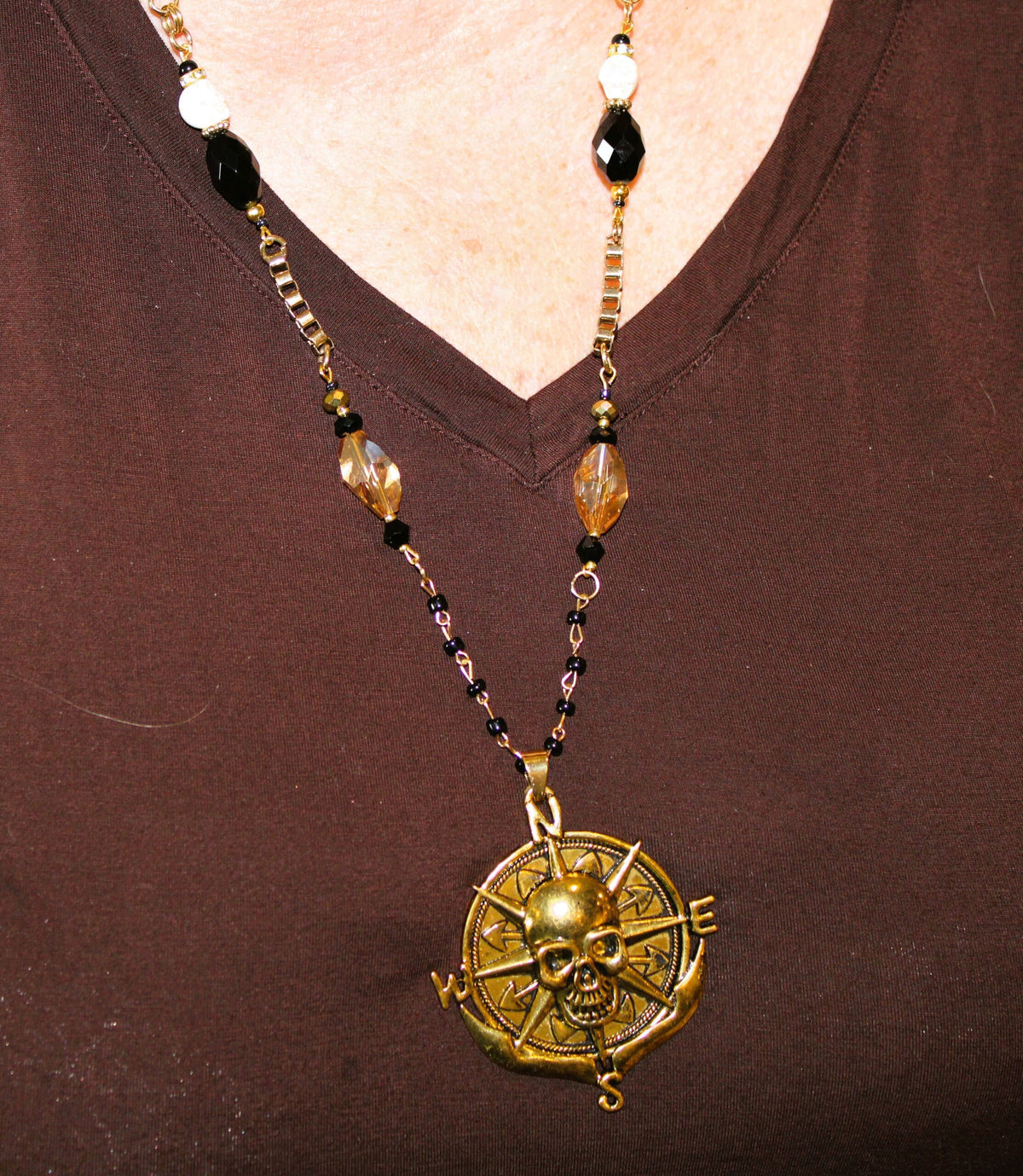 A woman wearing a necklace with a skull on it.