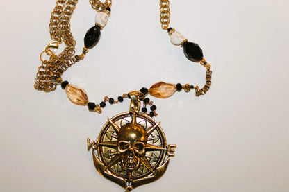 A necklace with a skull and compass on it.