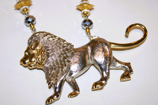 A necklace with a silver and gold lion pendant .