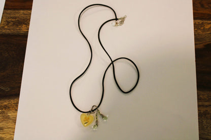 A necklace with a yellow heart on it.