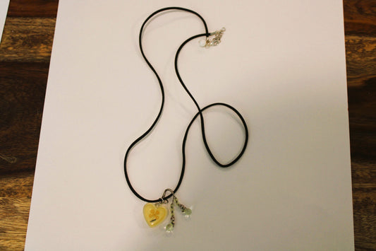 A necklace with a yellow heart on it.
